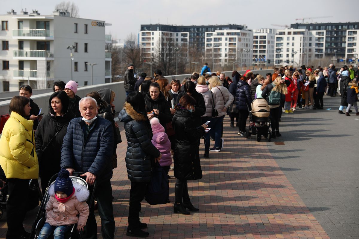 People fleeing from Ukraine wait in a line outside Tauron Arena sports hall where registration point for National Identification Number is opened, in Krakow, Poland on March 16, 2022. Tens of thousends Ukrainian refugees come to Poland due Russian invasion and from March 16 they can register in the Polish national PESEL identification number system. (Photo by Jakub Porzycki/NurPhoto via Getty Images)