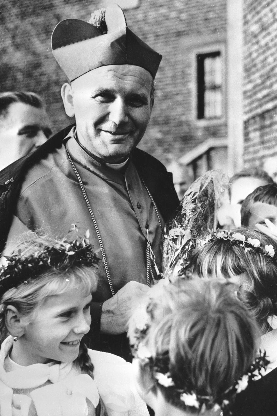 Cardinal Wojtyla With Little Girls1978:  Cardinal Karol Wojtyla, later Pope John Paul II, is surrounded by little girls during a visit to a village near Krakow.  (Photo by Keystone/Getty Images)Keystoneblack & white;format portrait;male;female;wreath;Personality;Rel