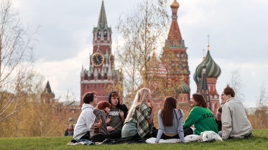 MOSCOW, RUSSIA - MAY 3, 2022: People sit on the grass in Zaryadye Park in central Moscow with the Moscow Kremlin and St Basil’s Cathedral seen in the background. Sergei Fadeichev/TASS