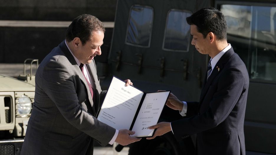 Sergij Korsuński Ambasador Ukrainy w Japonii, otrzymuje dokument od Toshiro Ino, ministra stanu Obrony Japonii, podczas ceremonii przekazania sprzętu obronnego dla Ukrainy w Ministerstwie Obrony w środę, 24 maja 2023 r., w Tokio