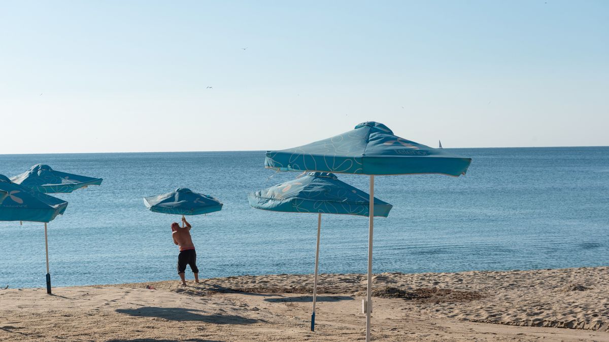 VARNA, BULGARIA - 2020/09/05: A man set up sunshade umbrellas on the beach in Varna on the Black Sea coast of Bulgaria. (Photo by John Wreford/SOPA Images/LightRocket via Getty Images)