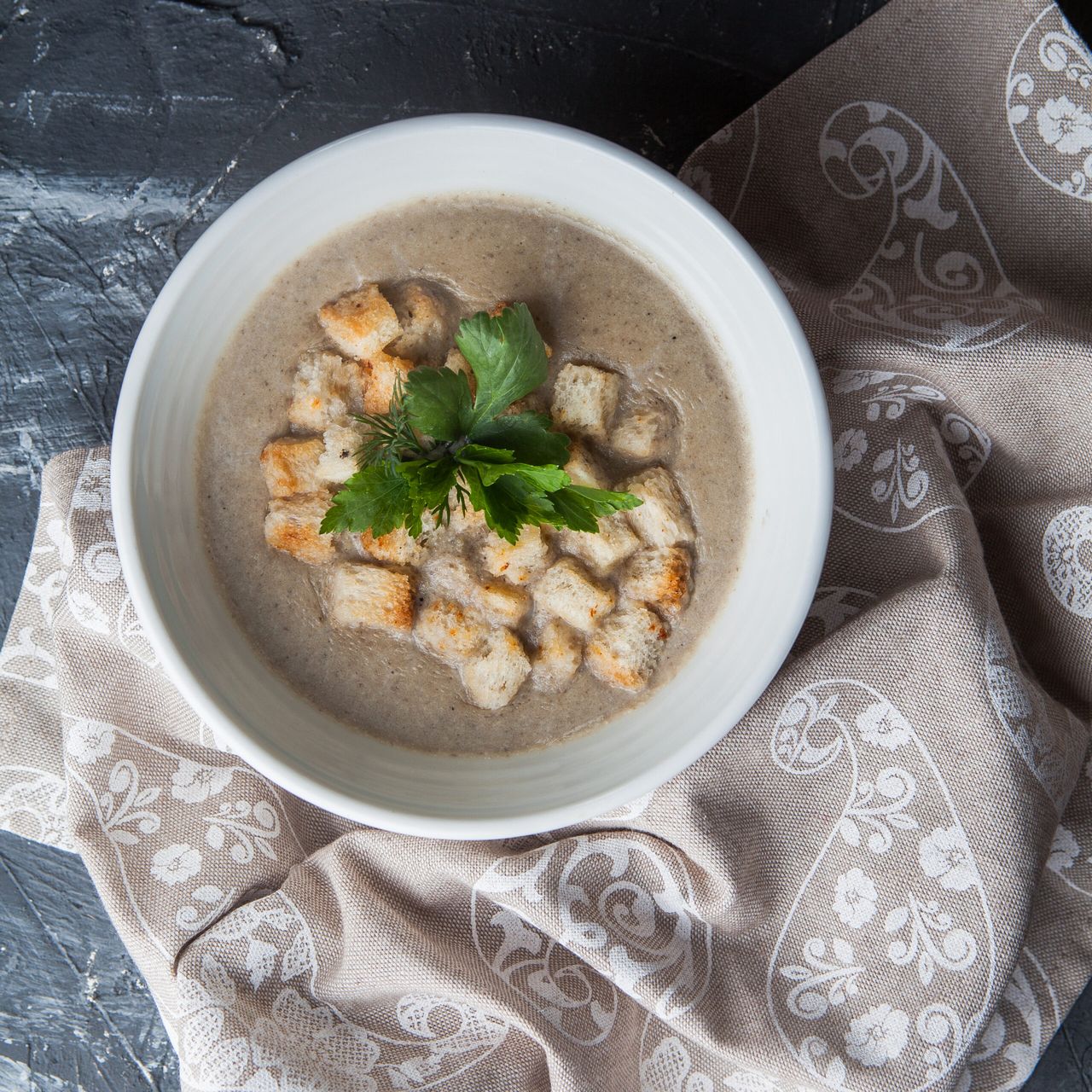 Top view mushroom soup with crackers and napkins on stone background