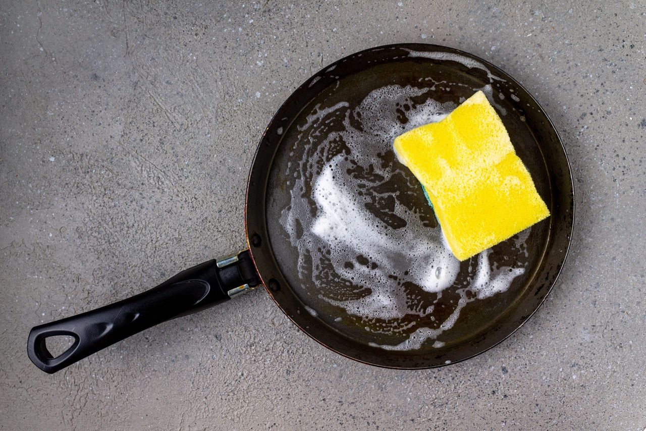 sponge for washing dishes, soap suds, frying pan, space for text