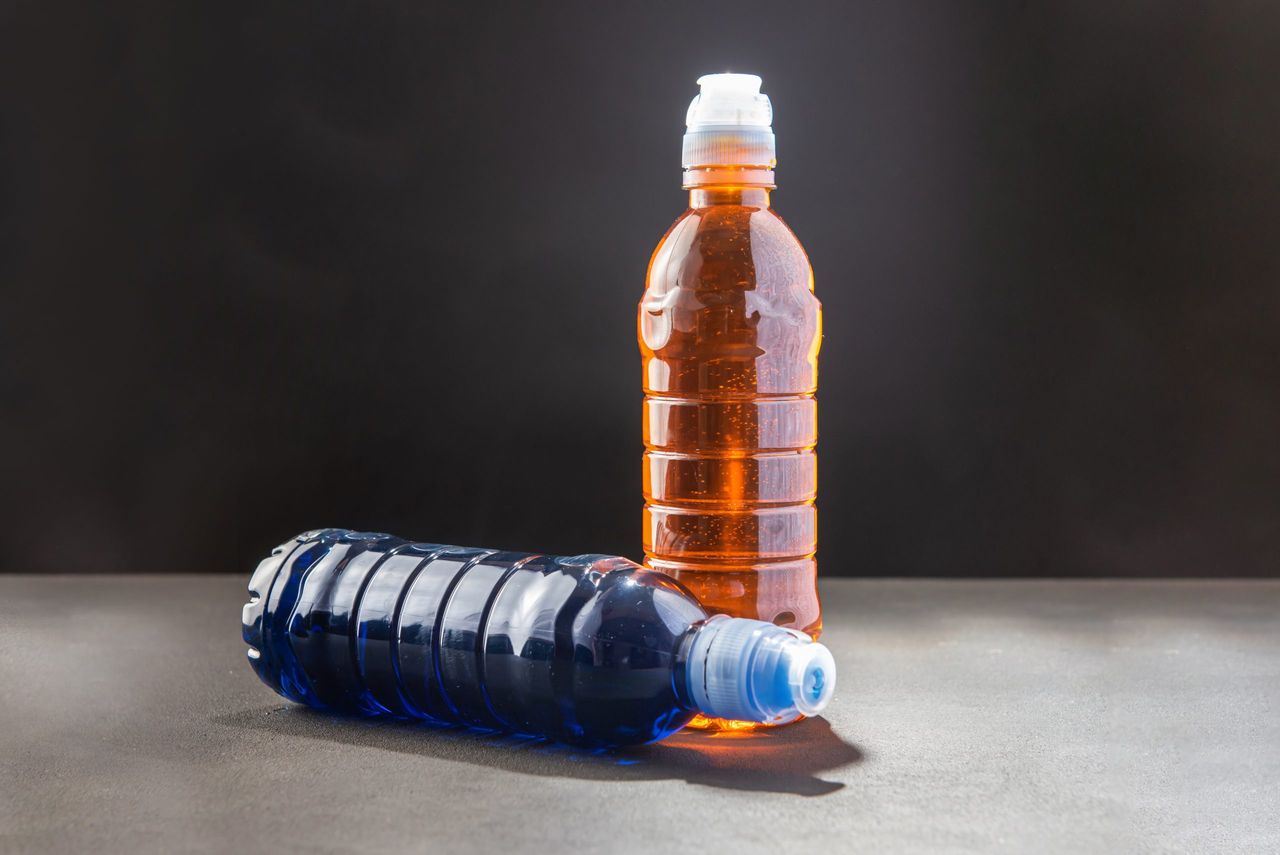 Two energy drinks blue and yellow for athletes on a dark background
