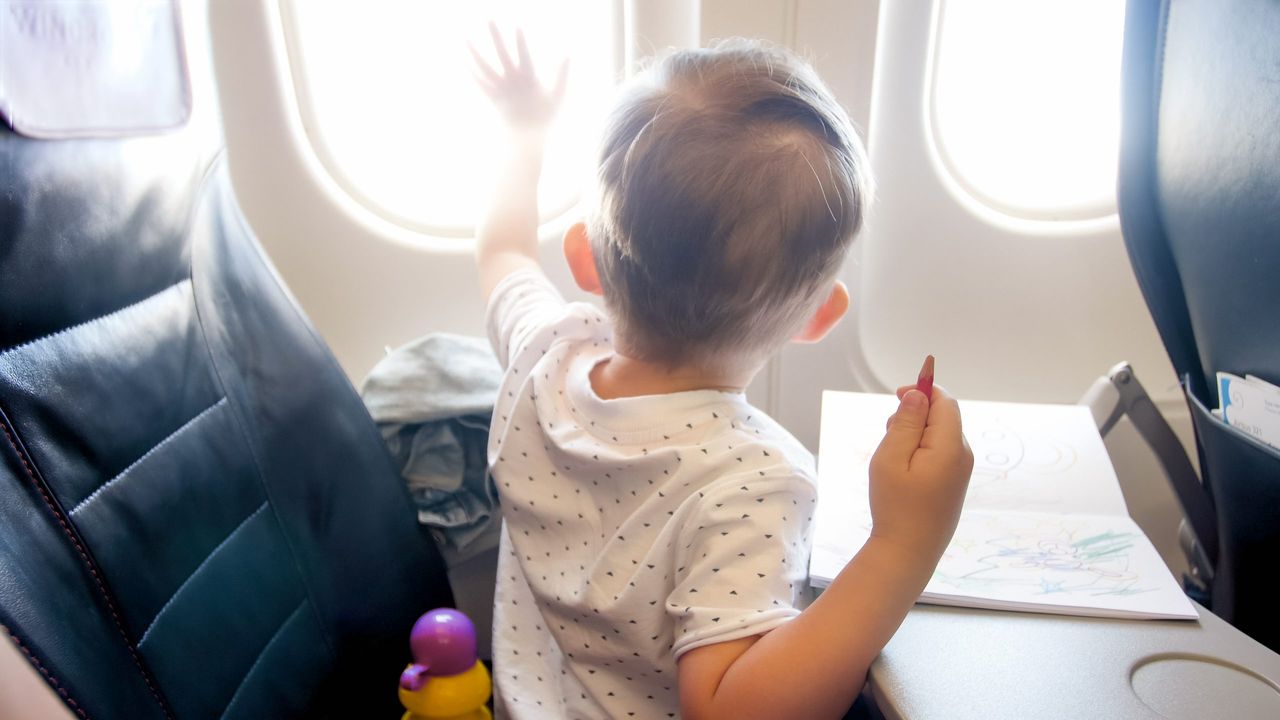 Cute little boy looking out of the window in airplane during flight.