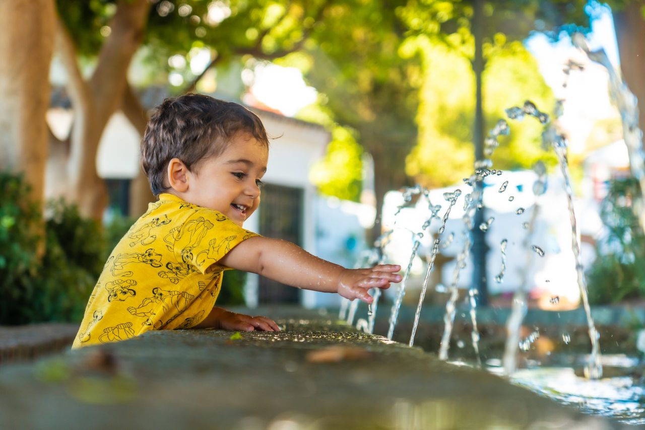 A baby cooling off from the heat in the fountain in the municipality of Mijas in Malaga. Andalusia