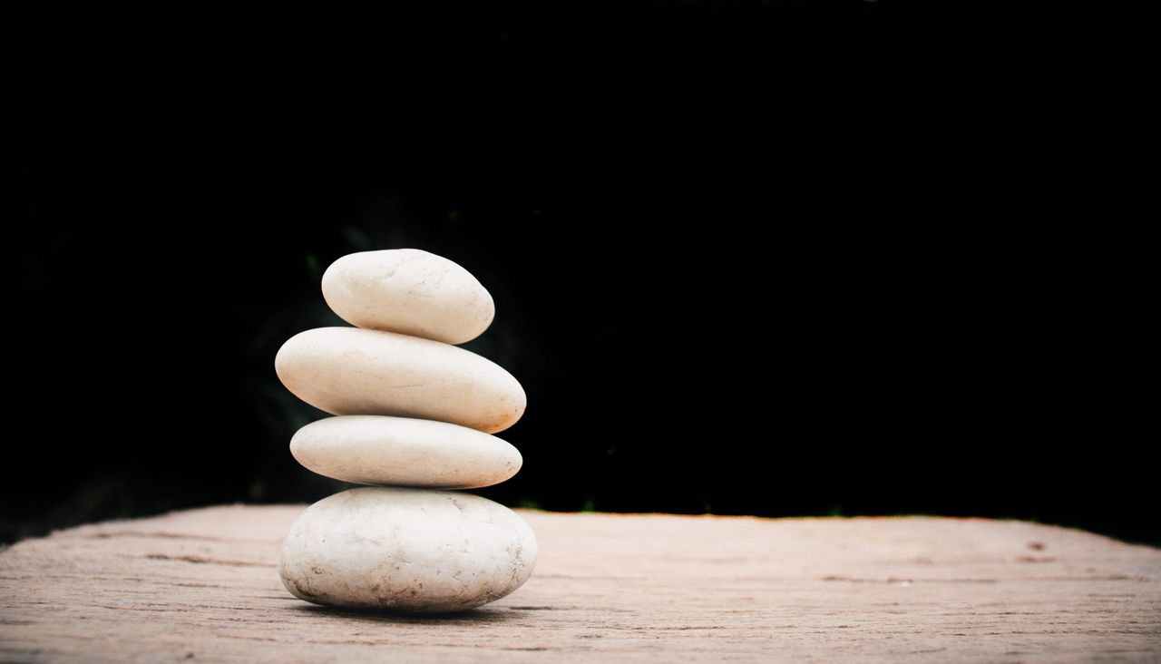 Zen stones on wooden on black background.Concept relaxation,zen,spring.