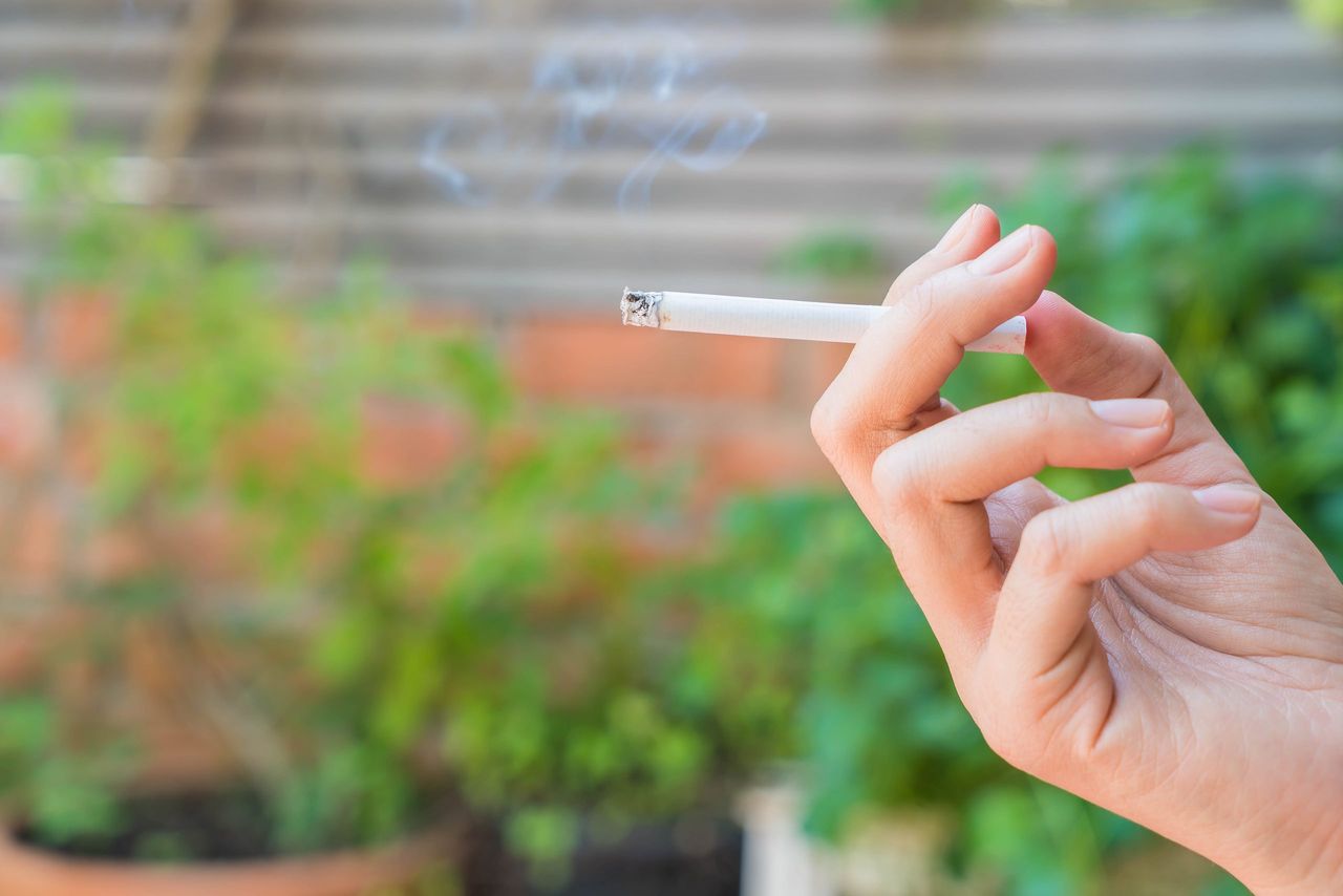 hand keeping cigarette with copy space