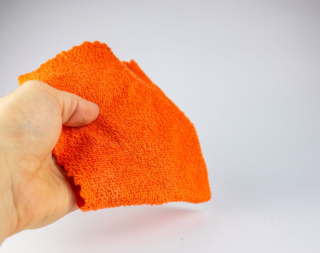 The Fiber cloth for cleaning. Rag for cleaning dust.Orange rag on a white background.