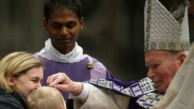 Papież Jan Paweł II posypuje popiołem główkę małego chłopca