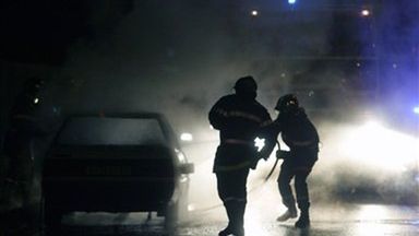 Francuscy strażacy dogaszają jedno z podpalonych aut