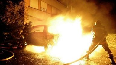 Strażak gasi jeden z płonących samochodów