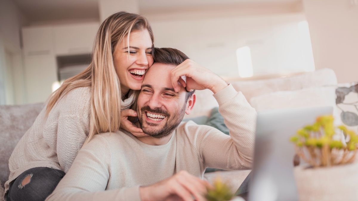 Close up of young couple working on laptop at home.