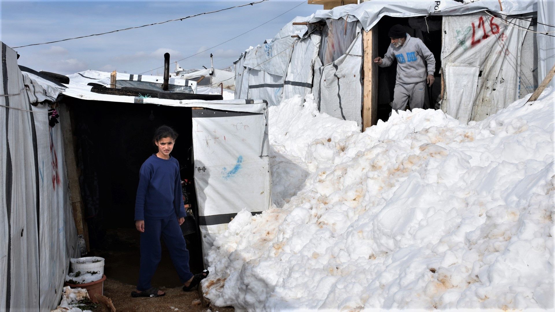 Mieszkańcy pokrytego śniegiem obozu dla uchodżców w Arsalu w Libanie