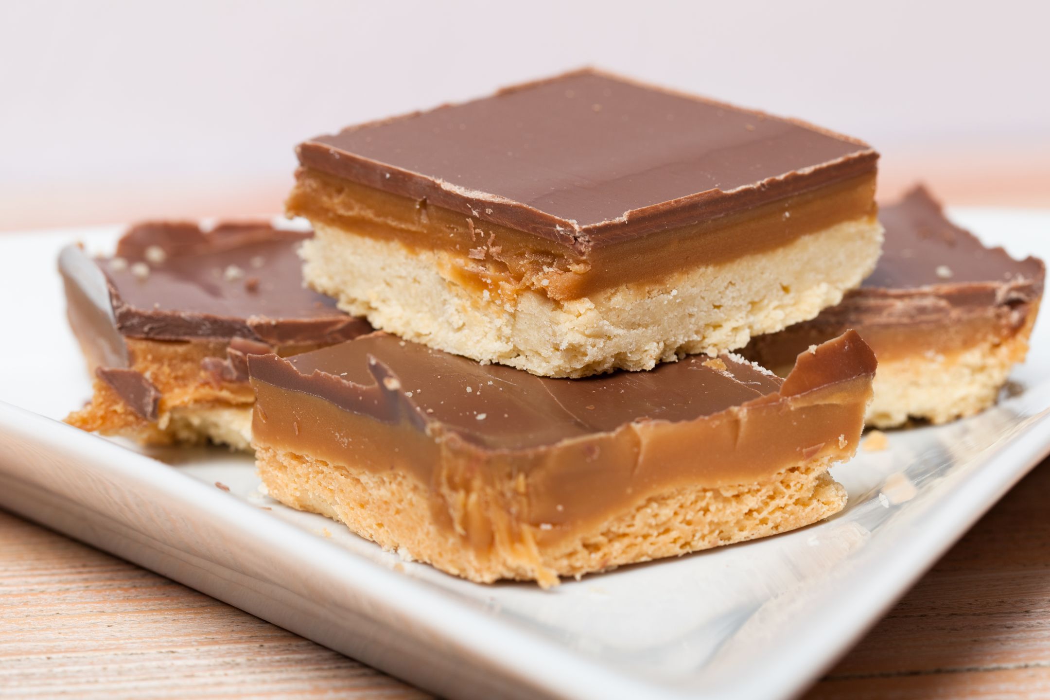 A closeup of some homemade chocolate and caramel millionaire's shortbread on a plate. 