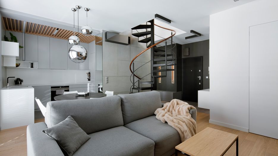 Industrialne elementy, stonowana szarość i ciepłe odcienie drewna. Mieszkanie na Żoliborzu