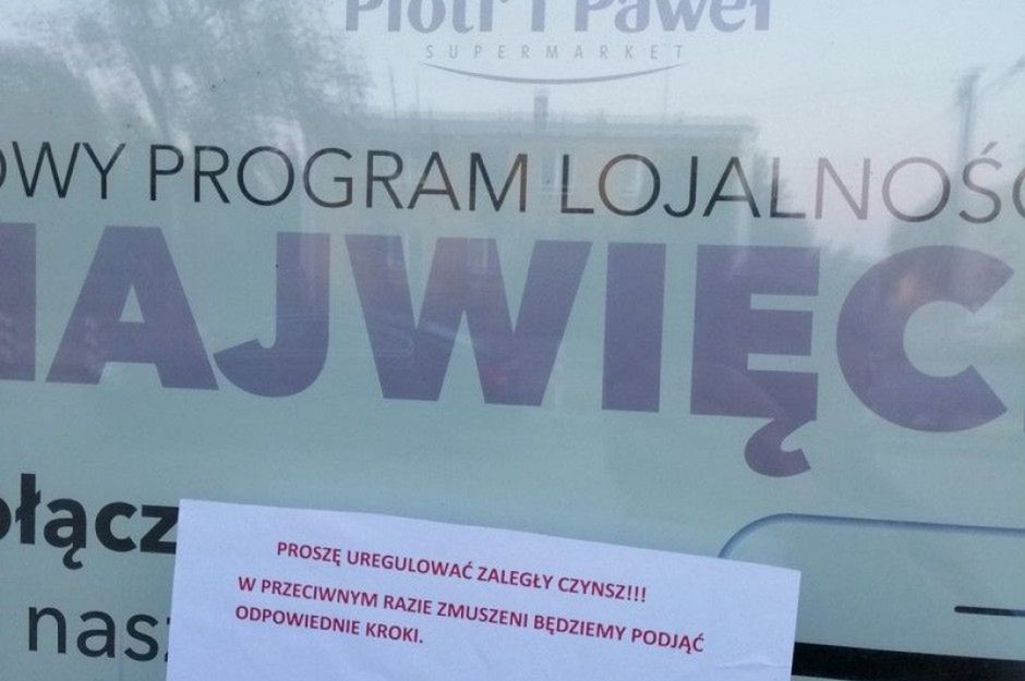 Sklep Piotr i Paweł. Zastawione wejście i karta z napisem "zapłać czynsz"