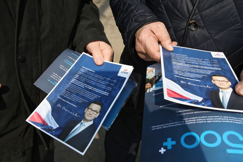 Mieszkańcy Otwocka z ulotkami reklamującymi nowe programy socjalne rządu.