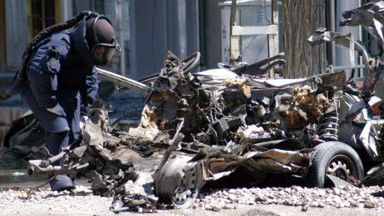 Policjant zabezpiecza wrak samochodu-pułapki