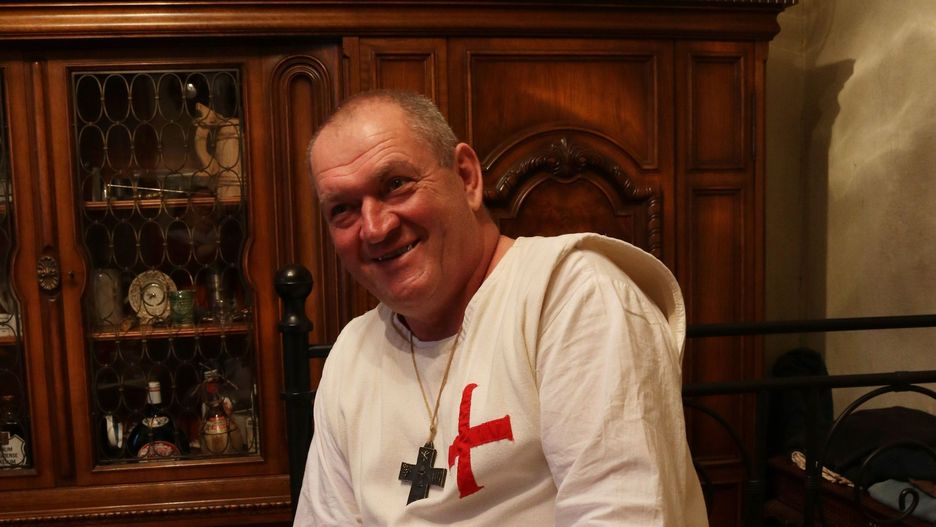Piotr Żurawicz w stroju templariusza opowiada o swojej pasiece.