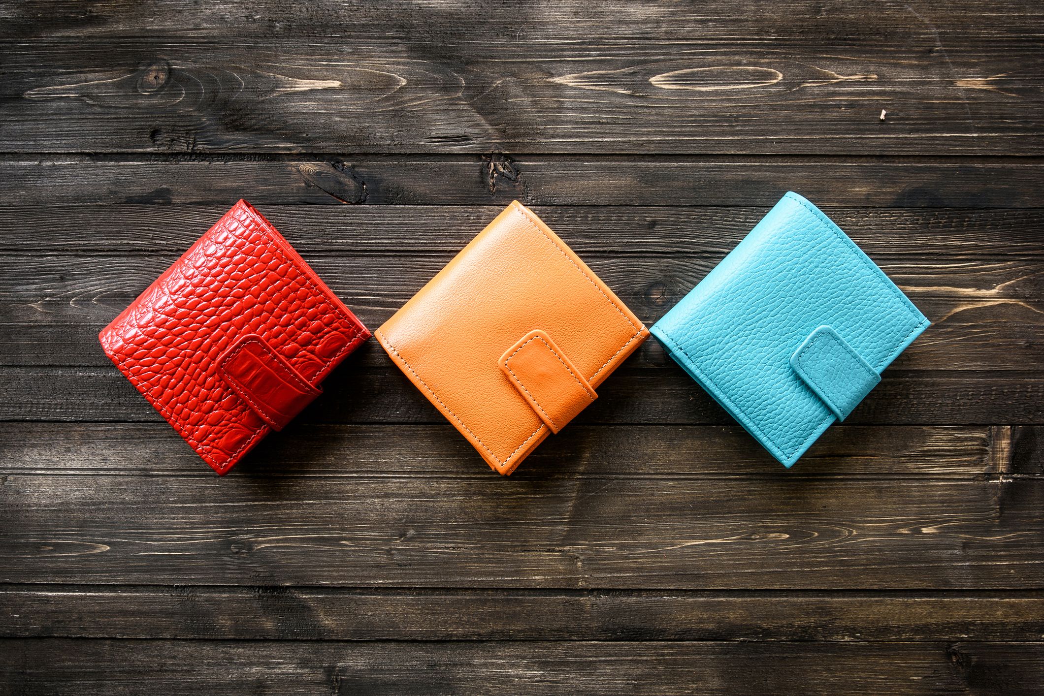 Group colorful Wallet of Leather skin on dark wooden background 