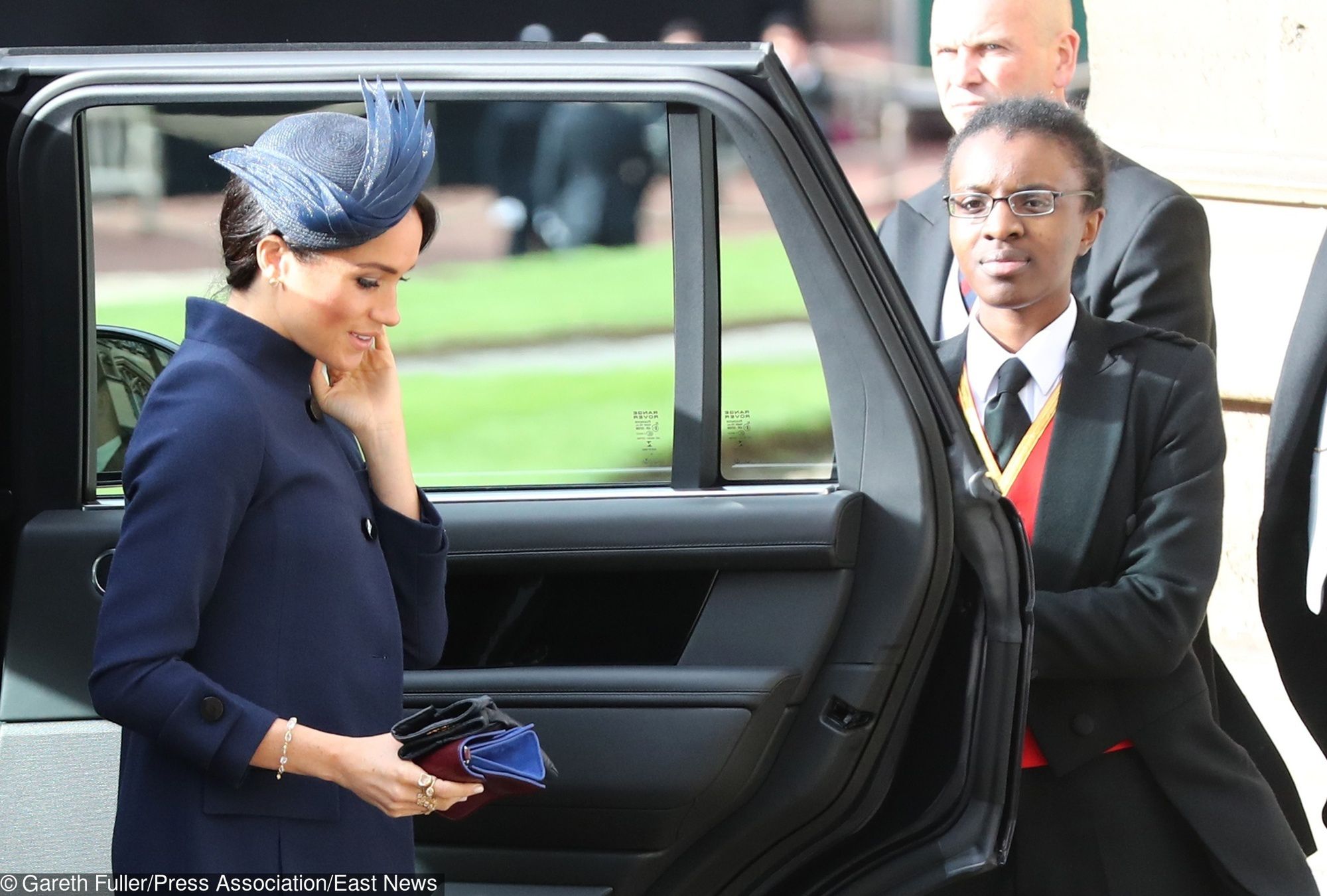 Księżna Meghan spodziewa się dziecka wiosną 2019 roku! Na ślubie księżnej Eugenii pojawiła się w luźnym, granatowym płaszczu 