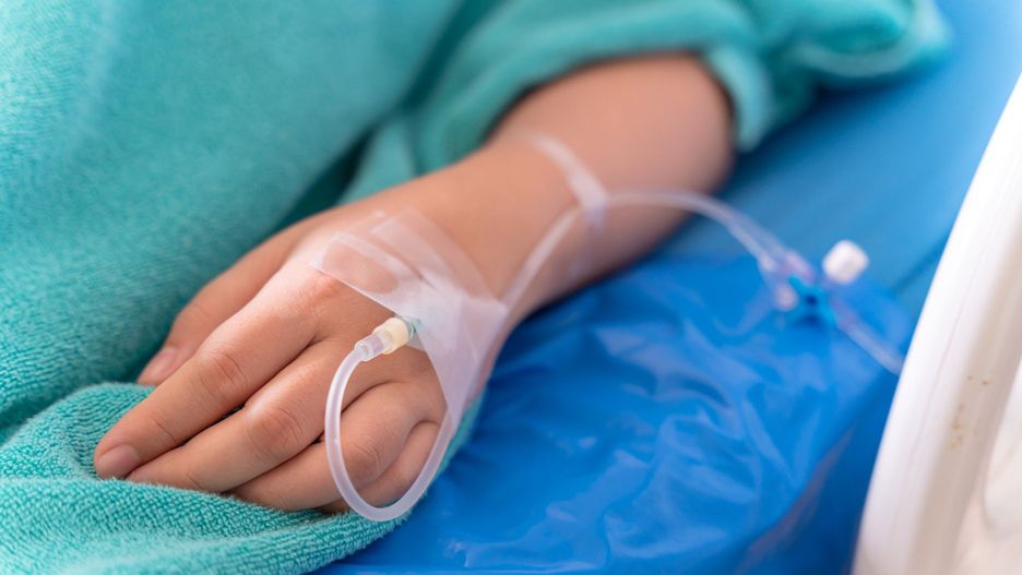 hand of the patient is on drip receiving a saline solution on bed VIP room at hospital. Medical Concept.