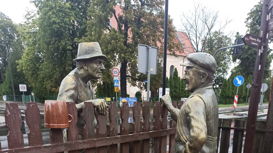 W centralnym punkcie wsi Dobrzykowice stoi płot, a po jego dwóch stronach Kargul i Pawlak