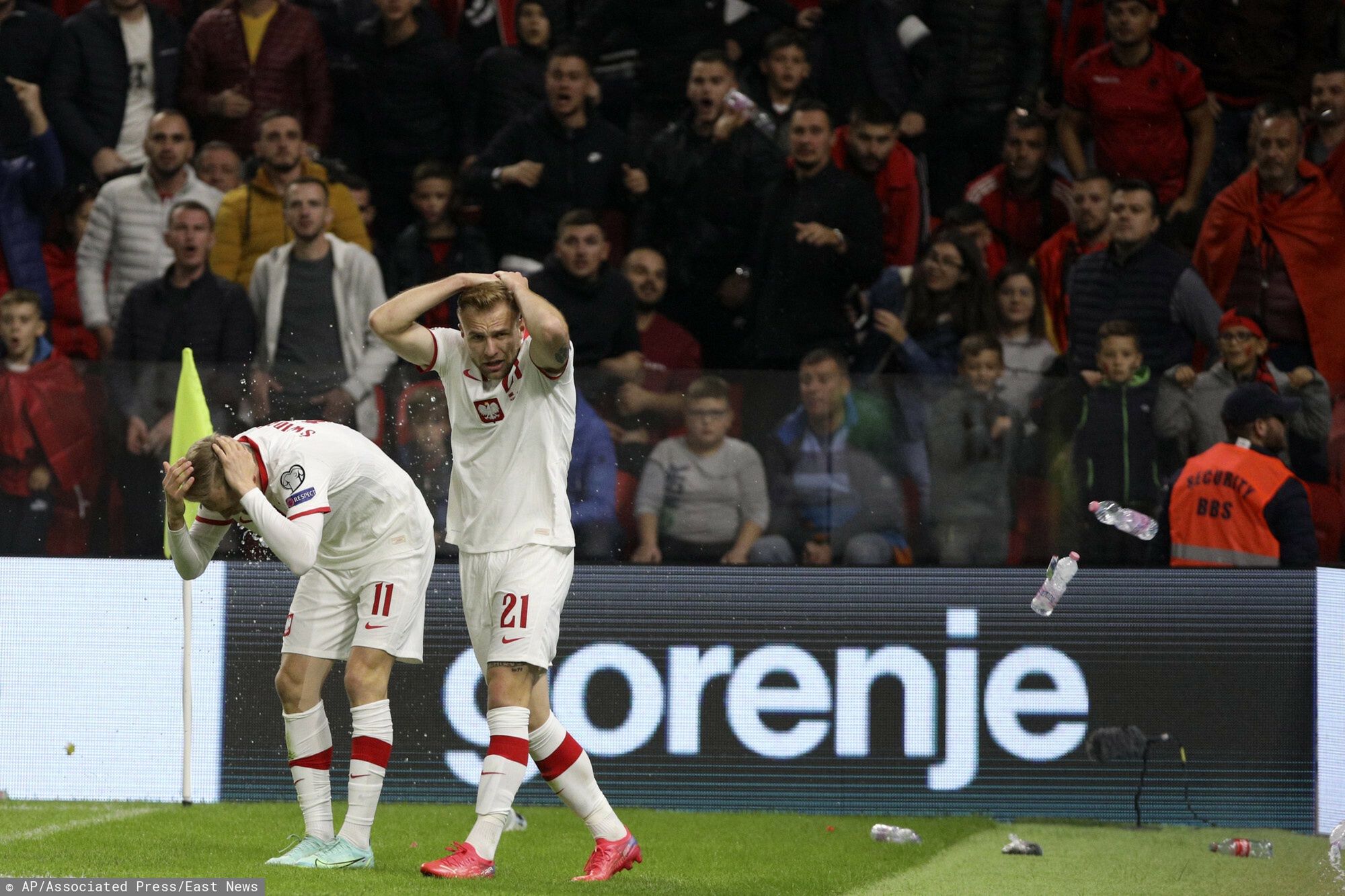 Eliminacje M? 2022 mecz Albania - PolskaPoland's Karol Swiderski, left, holds his head as fans threw items shortly after scoring the opening goal of his team during the World Cup 2022 group I qualifying soccer match between Albania and Poland at Air Albania stadium in Tirana, Albania, Tuesday, Oct. 12, 2021. (AP Photo/Franc Zhurda)AP