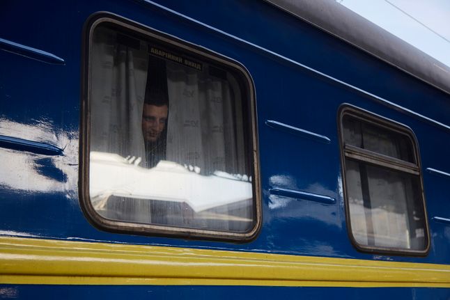 Mężczyzna spoglądający przez okno pociągu ewakuacyjnego z Kijowa.