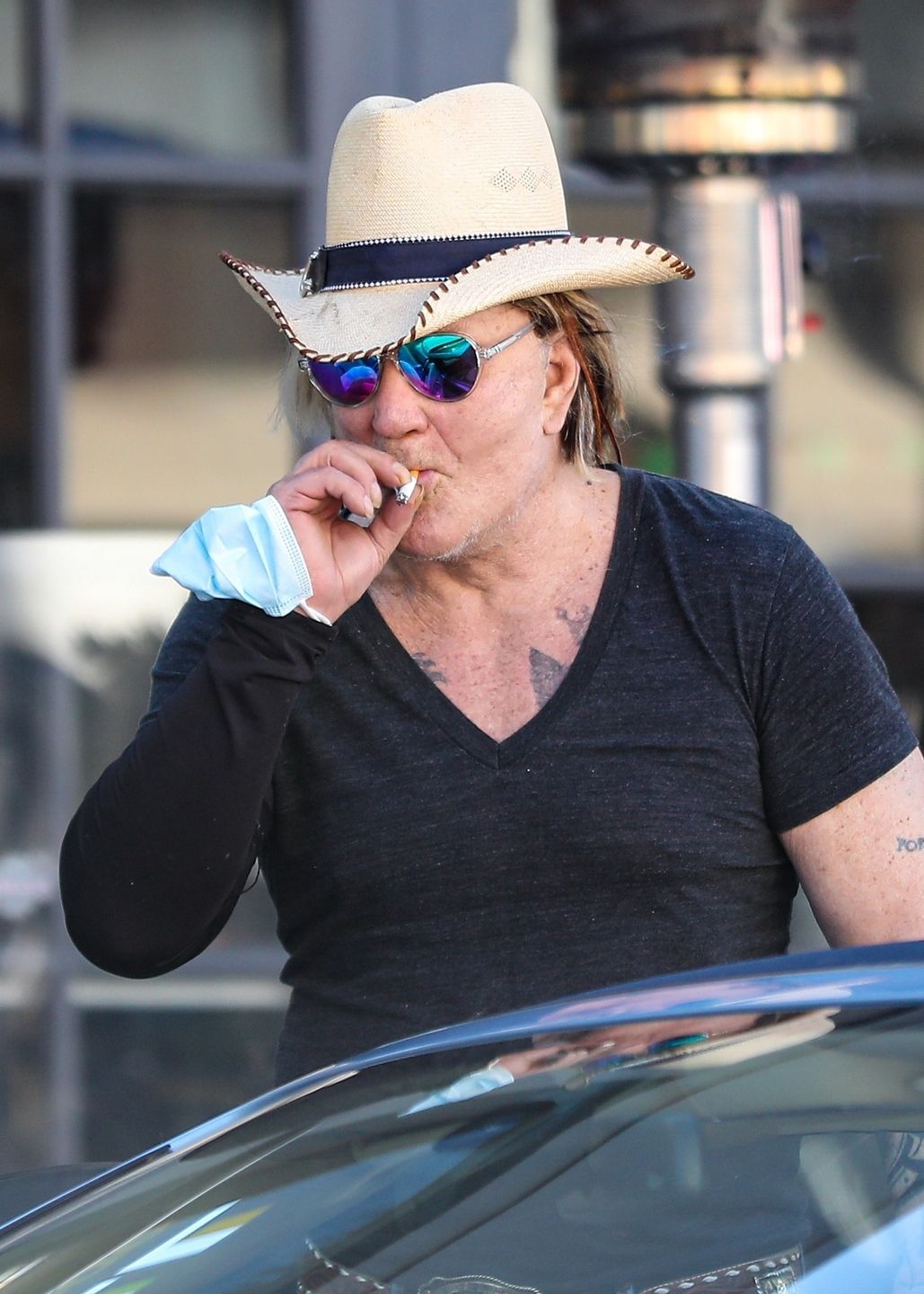 Zmarnowany Mickey Rourke wyłania się z samochodu w kowbojskim kapeluszu 