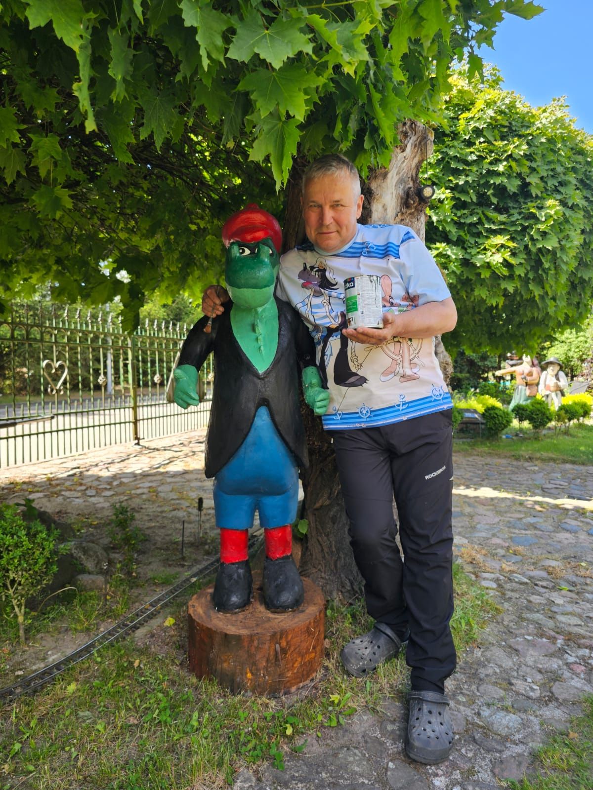 Tadeusz Żyła z Czarnego przy drewnianej rzeźbie w swoim ogrodzie
