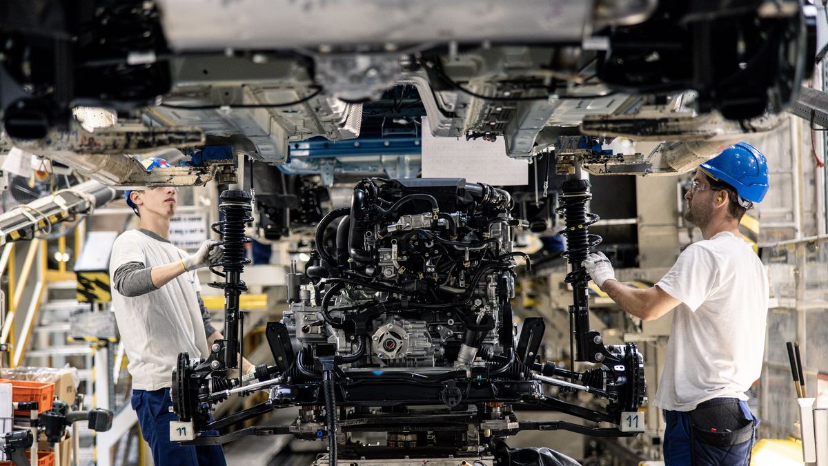 Employees adjust the suspension units for an automobile on the assembly line inside the Suzuki Motor Corp. plant in Esztergom, Hungary, on Wednesday, Oct. 19, 2022. European automotive stocks gained a boost from figures showing that new car sales in the region rose for a second month in September as supply-chain issues eased. Photographer: Akos Stiller/Bloomberg via Getty Images