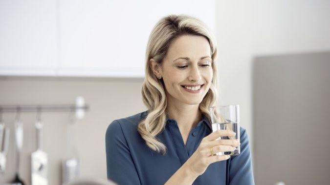 Pani pijąca filtrowaną wodę