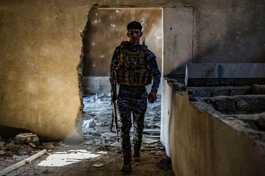 Irakijski policjant w zniszczonym kinie.