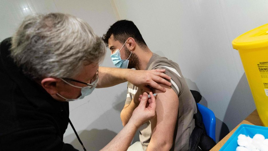 TemporaryA member of the public receives a dose of a Covid-19 vaccine inside a vaccination centre set up at Grim's Dyke Golf Club in north west London on December 26, 2021. - England pressed ahead with its Covid-19 immunisation campaign on Sunday in the race to inoculate as many people possible while the number of cases of the Omicron coronavirus variant soars. (Photo by Niklas HALLE'N / AFP)NIKLAS HALLE'N
