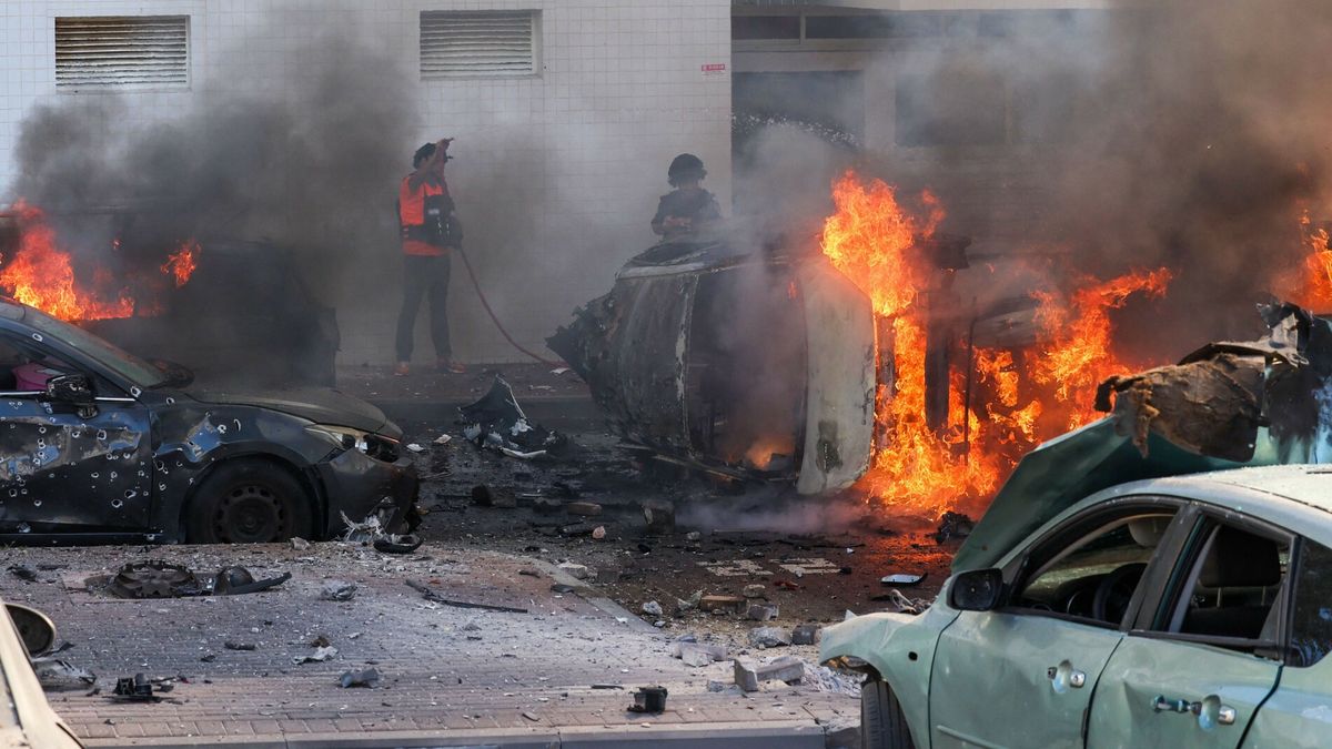 Atak rakietowy ze Strefy GazyPeople try to extinguish fire on cars following a rocket attack from the Gaza Strip in Ashkelon, southern Israel, on October 7, 2023. Palestinian militant group Hamas has launched a "war" against Israel, Defence Minister Yoav Gallant said, after barrages of rockets were fired from the Gaza Strip into Israeli territory on October 7. (Photo by AHMAD GHARABLI / AFP)AHMAD GHARABLI