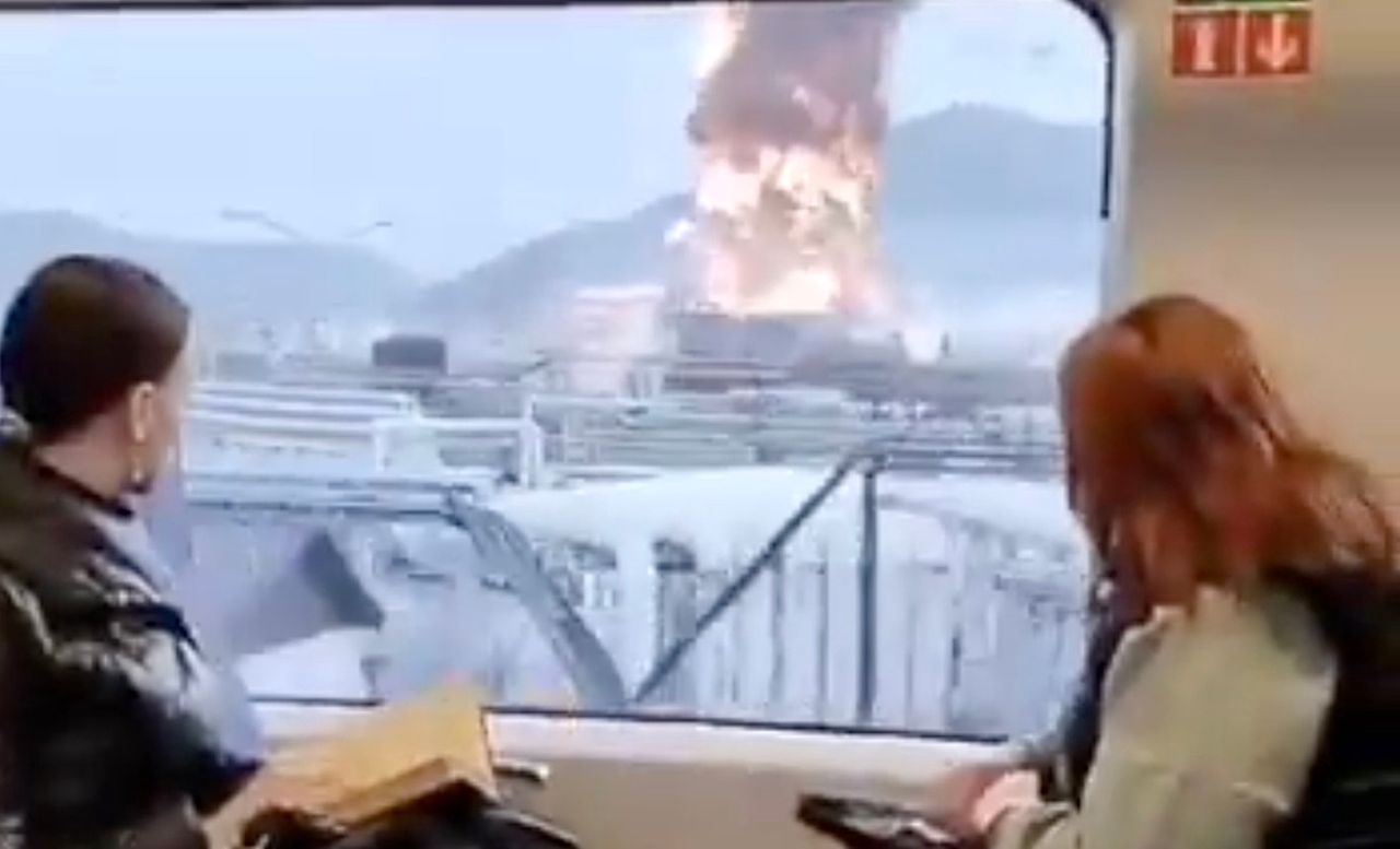 A still from a video on a train in Russia - passengers watch a burning refinery