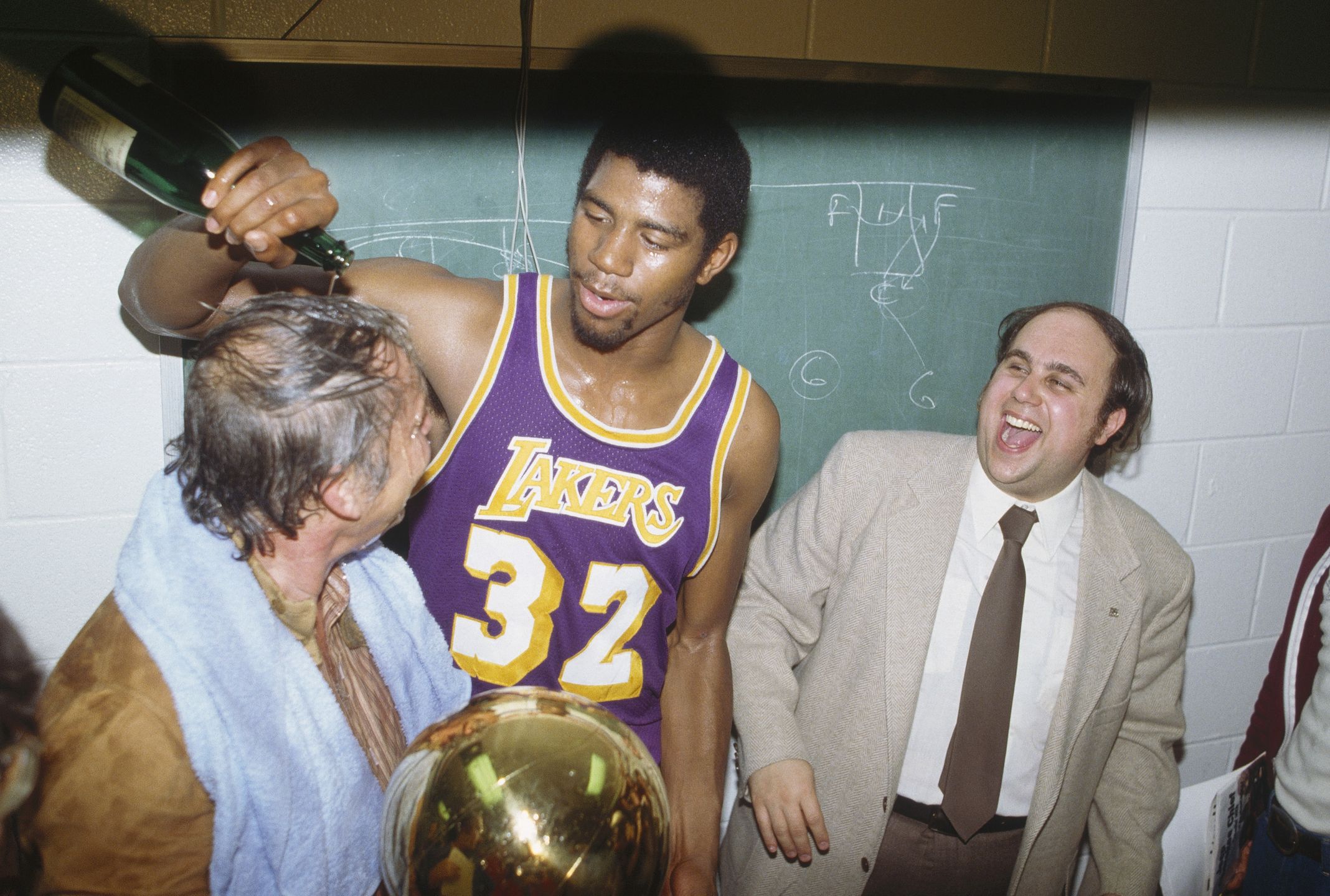 Magic Johnson wylewa szampana na Jerry'ego Bussa po zwycięskim meczu w 1980 r.