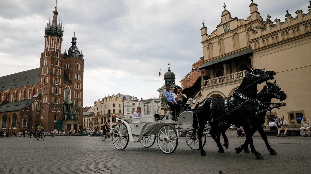 KRAKOW, POLAND - 2022/06/07: People are seen inside the carriage while riding in the Rynek Glówny (market square) in the Krakow (Cracow) Old town. Krakow is the one of the oldest cities in Poland. Thousands of tourists visit yearly. Also it is the second-largest city in the country. (Photo by Volha Shukaila/SOPA Images/LightRocket via Getty Images)