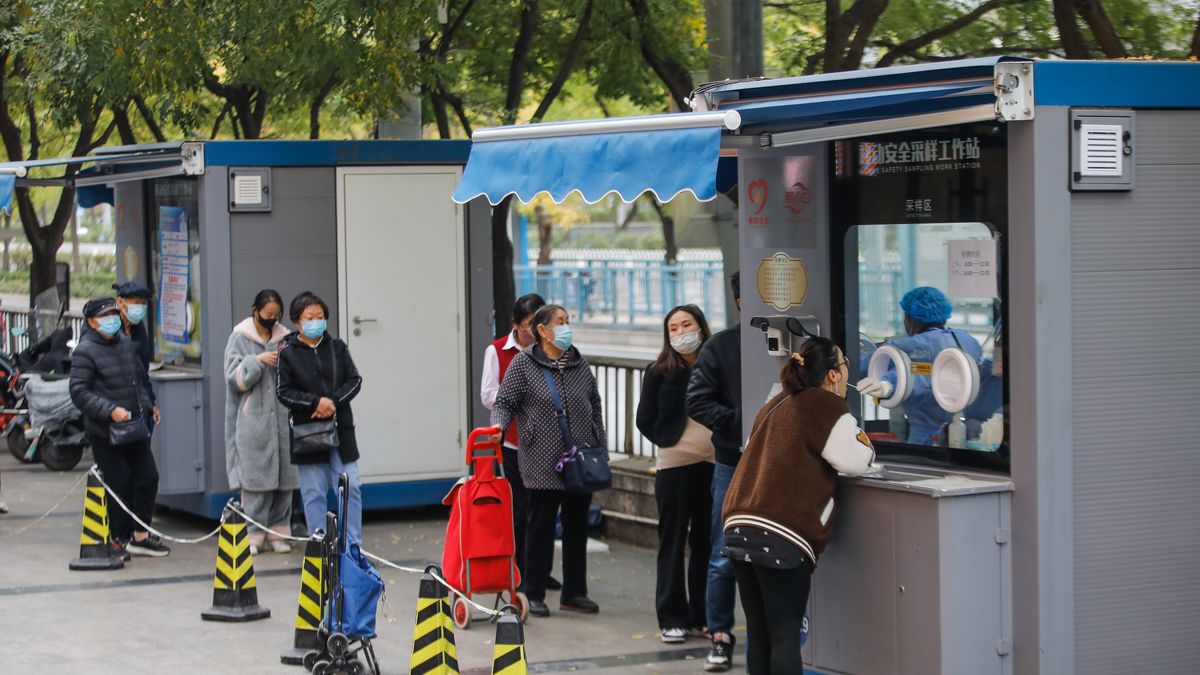Na zdjęciu osoby w Chinach czekające w kolejce na wymaz