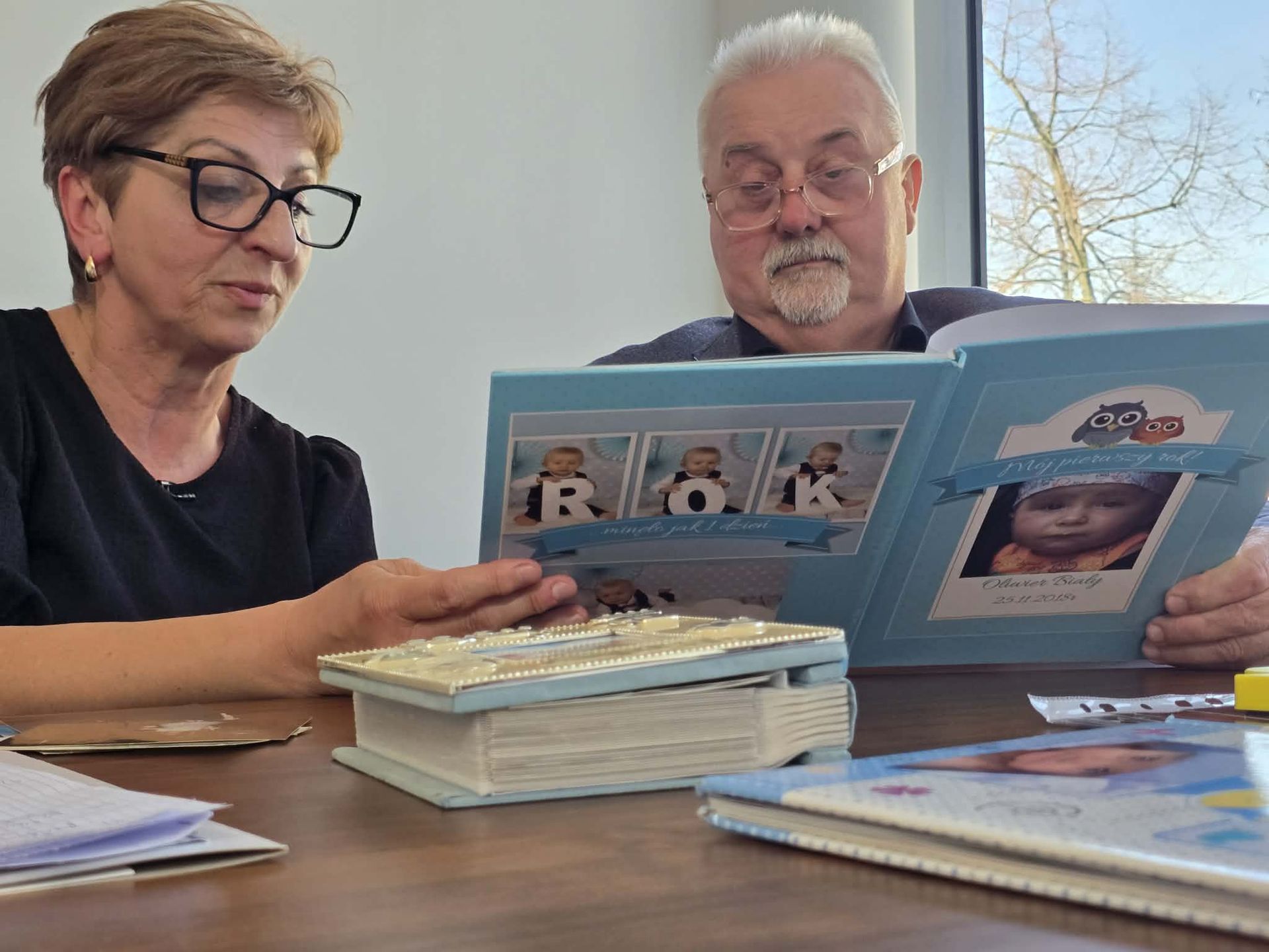 Małgorzata i Janusz Dudowie przeglądają rodzinne archiwum