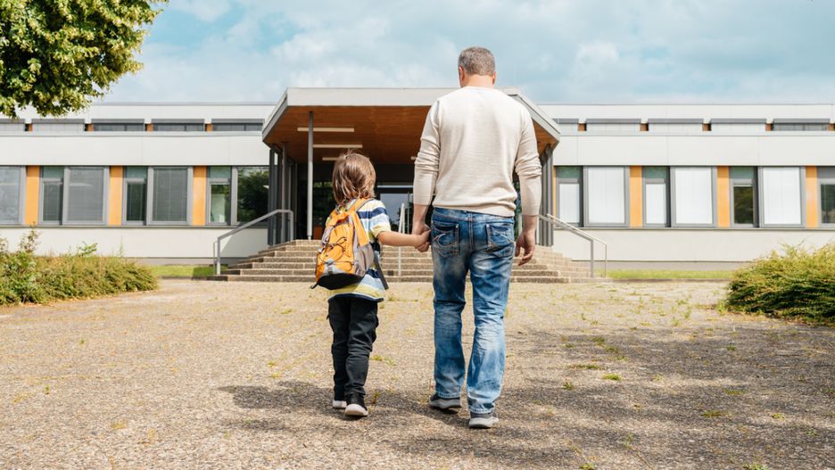 Rodzic, który prowadza swoje dziecko do przedszkola