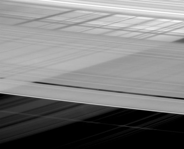 Zbliżenie na pierścienie Saturna ujawnia obraz, na którym powstaje jakby poprzecinana powierzchnia. W rzeczywistości są to cienie innych pierścieni. W centrum obrazu można dojrzeć malutki księżyc – Pan, którego średnica wynosi zaledwie 28 kilometrów. Obraz został zarejestrowany 11 lutego 2016 roku z odległości 1,9 miliona kilometrów od Pana.