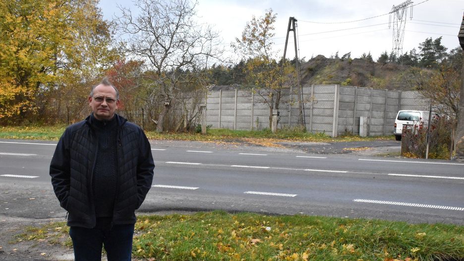 Dariusz Sibielski alarmuje o problemie mieszkańców Starych Bielic. Na zdjęciu na tle składowiska odpadów budowlanych.