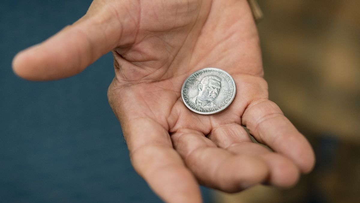 MIAMI, UNITED STATES - August 30: Deacon Milton Devoe shows a Booker T. Washington half-dollar coin at Friendship Missionary Baptist Church in Liberty City, Florida on August 30, 2023. Booker T. Washington was the first free Black person featured on US currency. (Photo by Bryan Cereijo for The Washington Post via Getty Images)