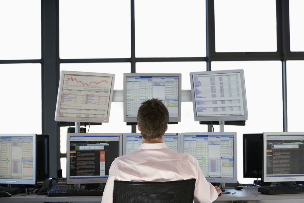 Zdjęcie Rear view of stock trader pochodzi z serwisu Shutterstock