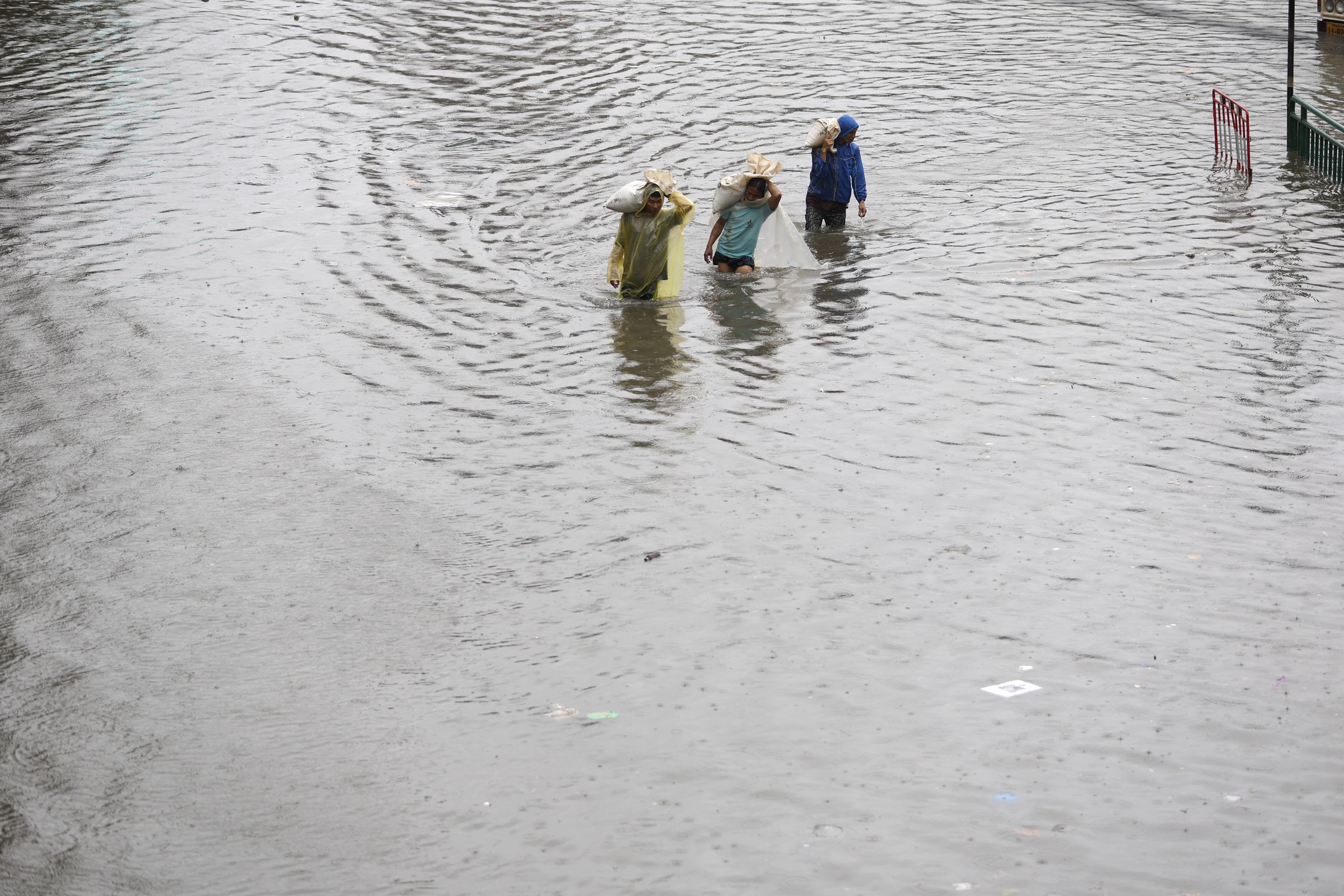 People carrying sand bags wade through floodwater during a downpour in Bangkok, Thailand, 26 September 2026. All 50 districts in Bangkok have been declared flood disaster zones following the non-stop heavy downpour caused by a strong low-pressure system combined with seasonal monsoon patterns. EPA/RUNGROJ YONGRIT Dostawca: PAP/EPA.