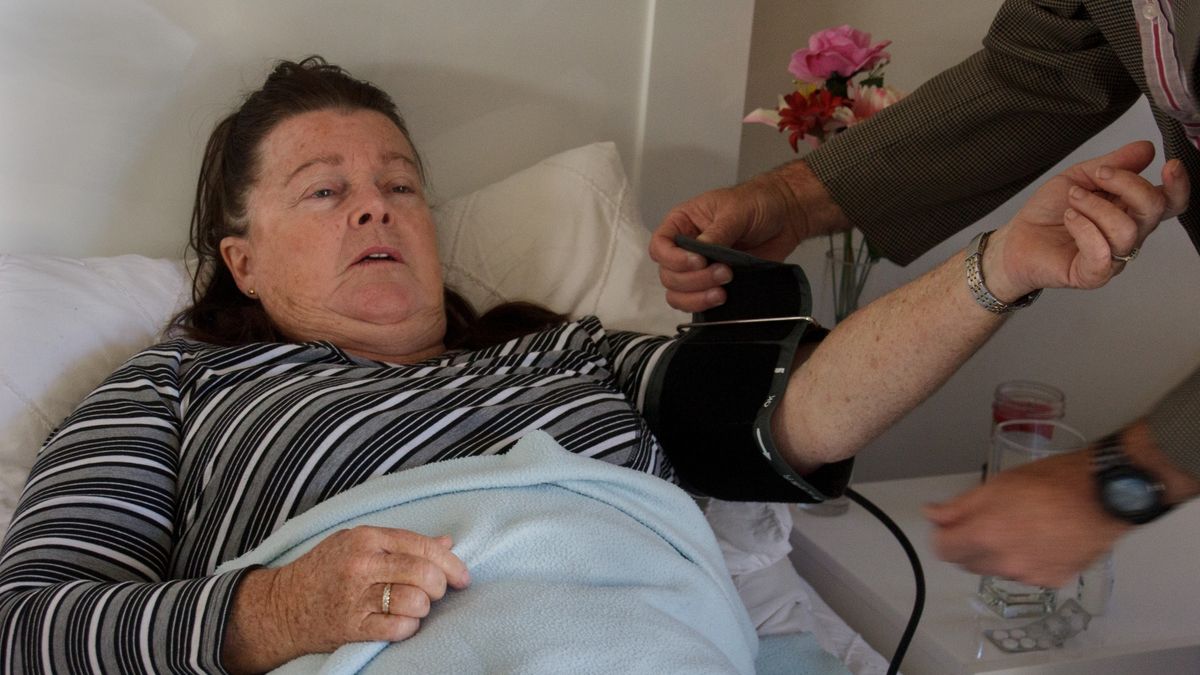 Close up of sick woman at home with male Caregiver
Close up of male doctor at bedside using blood pressure cuff (sphygmomanometer) with female patient in bed during at home visit
Michelle Lehr