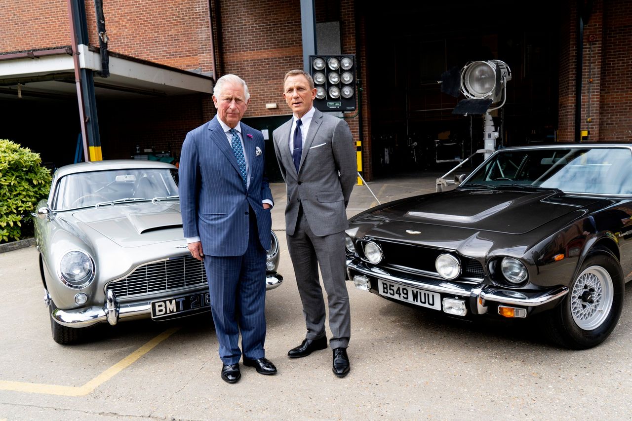 Daniel Craig i Książę Karol przy filmowych Astonach Martinach DB5 i V8 Vantage